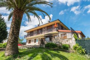 a palm tree in front of a house at Casa Madrazo con piscina y parrillas in Praves