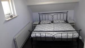 - une chambre avec un lit noir et 2 oreillers dans l'établissement Duinnachtegaal, à Egmond aan Zee