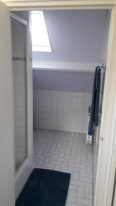 baño con ducha y alfombra azul en Duinnachtegaal, en Egmond aan Zee