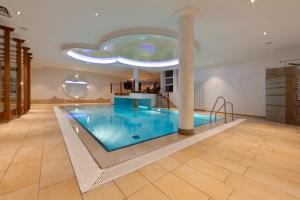 a swimming pool in a building with a ceiling at Ringhotel Am Stadtpark in Lünen