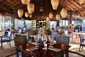 a dining room with tables and chairs and chandeliers at The Beach Tulum Hotel in Tulum