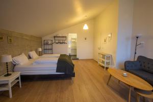 a bedroom with a bed and a couch and a table at Vogur Country Lodge in Vogur