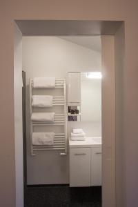 a white bathroom with a sink and towels at Vogur Country Lodge in Vogur