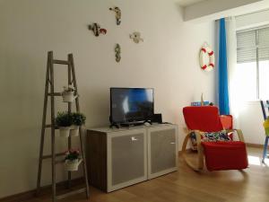 アルマカオ・デ・ペラにあるGui Beach Houseのリビングルーム(テレビ、赤い椅子付)