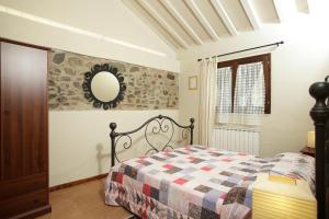 una camera da letto con un letto e uno specchio a parete di Osteria I'Casolare a San Giovanni Valdarno