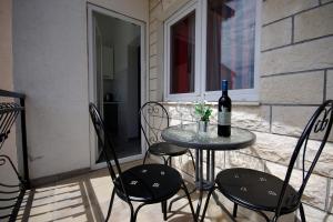 a table with a bottle of wine and two chairs at Apartment Ivan in Kastel Sucurac