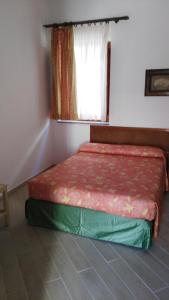 a bed sitting in a room with a window at La Sirenetta Park Hotel in Stromboli