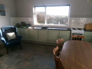 a kitchen with a table and chairs and a window at teach donal og in Falcarragh