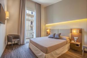 ナポリにあるB&B Dimora San Feliceのベッドと窓が備わるホテルルーム
