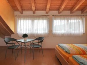 a room with a table and chairs and two beds at Ferienwohnung Graf in Vogtsburg