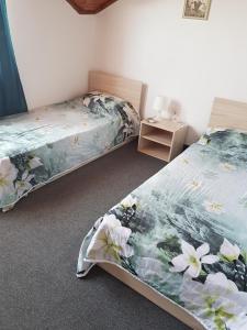a bedroom with two beds and a table with a night stand at Guest Rooms Radost in Balchik