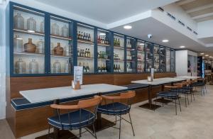 a restaurant with tables and chairs and shelves of wine bottles at Rosamar Es Blau 4*s - Adults Only in Lloret de Mar