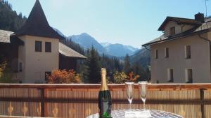 BnB Ernesto Langwies - NOT Davos في Langwies: طاولة مع كأسين من النبيذ فوق السياج
