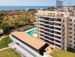 an aerial view of a building with a pool and the ocean at Interpass Vau Hotel Apartamentos in Portimão