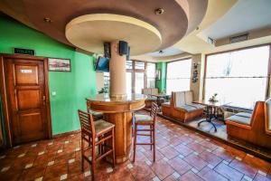 un bar en una habitación con una pared verde en Hotel Premier Centar, en Bitola