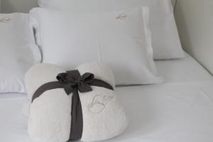 a white towel with a black bow on a bed at Apartman Bombon in Selce