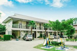 un edificio con un parque infantil delante de él en Palm Sweet Resort, en Chumphon