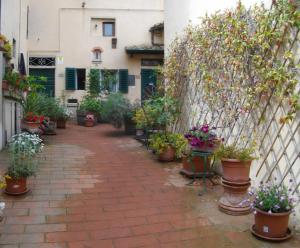 a courtyard with potted plants and a fence at La Corte del Frate in Podere Panzano