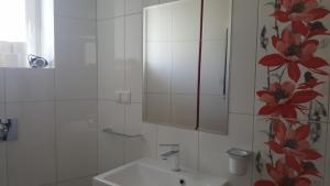 a white bathroom with a sink and a mirror at Apartament Centrum 2 in Mikołajki
