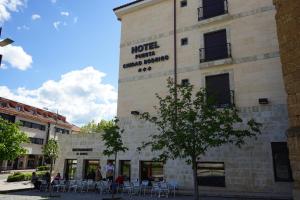 un bâtiment avec des tables et des chaises devant lui dans l'établissement Hotel Puerta Ciudad Rodrigo, à Ciudad-Rodrigo