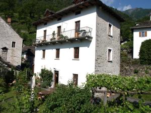 ein weißes Gebäude mit Balkon darüber in der Unterkunft Pensione Ca' Serafina in Lodano