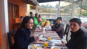 un grupo de personas sentadas en una mesa en un restaurante en Killari Hostal Ollantaytambo, en Ollantaytambo