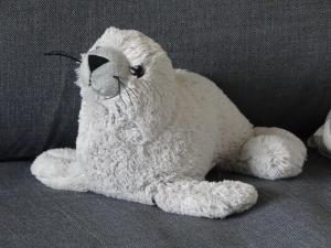 a white teddy bear sitting on a couch at Ferienwohnung Robbe in Bremerhaven