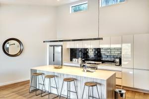 cocina con encimera y taburetes en Modern Luxe House with Magnificent View, en Queenstown 22 fotos más