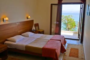 una camera d'albergo con un letto e una grande finestra di Sunset Hotel a Xiropigado