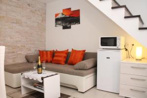 a living room with a couch and a tv at Apartman Bombon in Selce