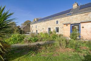 a brick house with a garden in front of it at Les Jardins de Coët-Kra in Plaudren