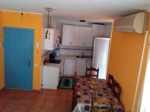 a kitchen with a table and a blue door at Bonito apartamento in Las Negras