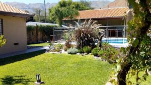 a yard with a house and a swimming pool at Hostería Boutique El Puente Adults Only in Merlo
