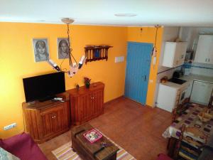 a living room with a flat screen tv and a kitchen at Bonito apartamento in Las Negras