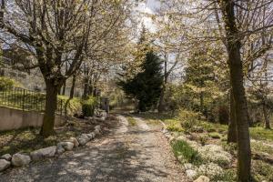 a path in a park with trees and a fence at B&B Il Mirtillo in Moncrivello