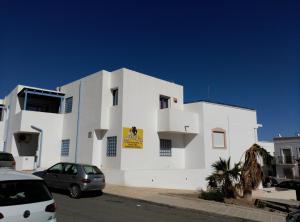 a white building with cars parked in front of it at Bonito apartamento in Las Negras