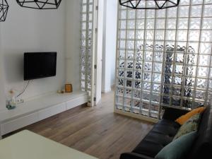 バレンシアにあるModerno Apartamento en la playa del Cabanyalのリビングルーム(ソファ、壁掛けテレビ付)