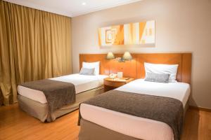 una habitación de hotel con 2 camas en una habitación en Plaza Barra First, en Río de Janeiro