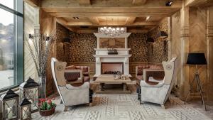 a living room with a fireplace and a table and chairs at Bachleda Hotel Kasprowy in Zakopane