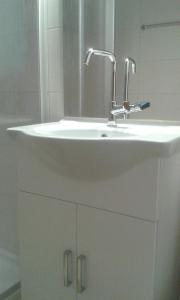 een witte wastafel in een badkamer met een spiegel bij Ferienwohnung Angelika in Schruns