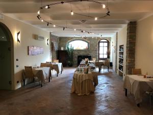 a dining room with tables and chairs and a fireplace at Albergo Castiglione Langhe in Castiglione Tinella