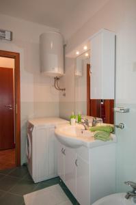 W białej łazience znajduje się umywalka i lustro. w obiekcie Dragica w mieście Lovran