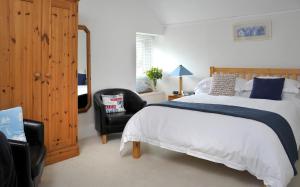 a bedroom with a large bed and a black chair at Surf Haven in Bude