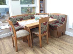バセンスウェイトにあるSouth View Bassenthwaite Bed and Breakfastの木製テーブル(椅子2脚、テーブル1台、椅子1脚付)