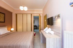 a hotel room with a bed and a flat screen tv at Cozy Guest House in Rethymno