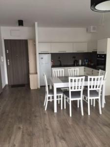 a kitchen with a table and chairs in a room at Apartament Baltic Park in Pogorzelica