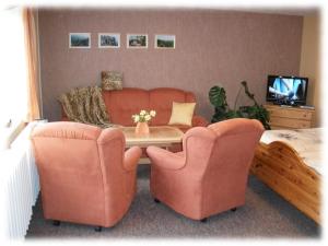 a living room with two chairs and a table and a couch at Fewo Hoyer in Hinterhermsdorf