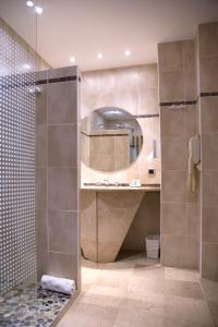 uma casa de banho com um chuveiro e um espelho. em Grand Hôtel Du Lido em Argelès-sur-Mer