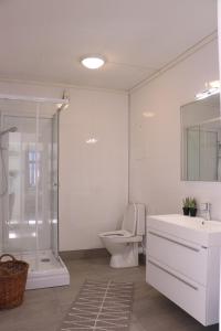uma casa de banho com um WC, um chuveiro e um lavatório. em Valldal Gjestgiveri em Valldal