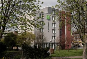 un edificio blanco con un letrero verde. en ibis Styles Hotel Gelsenkirchen en Gelsenkirchen